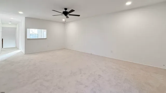 an empty room with a window and a ceiling fan