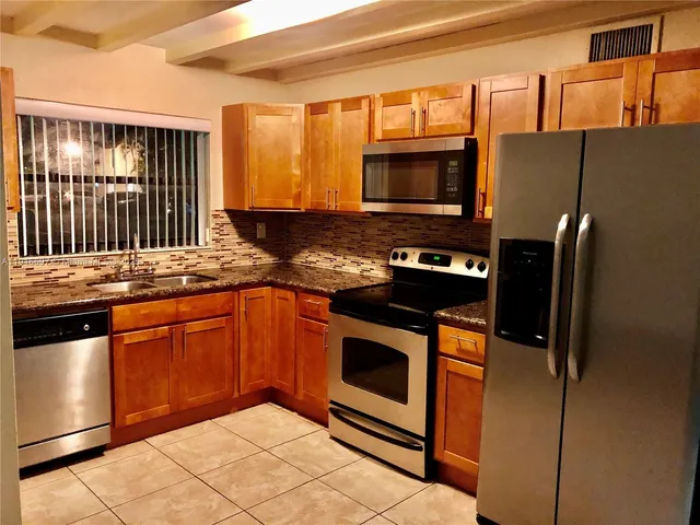 a kitchen with stainless steel appliances granite countertop a refrigerator stove and sink
