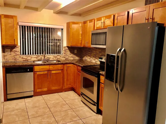 a view of an empty room with a chandelier fan