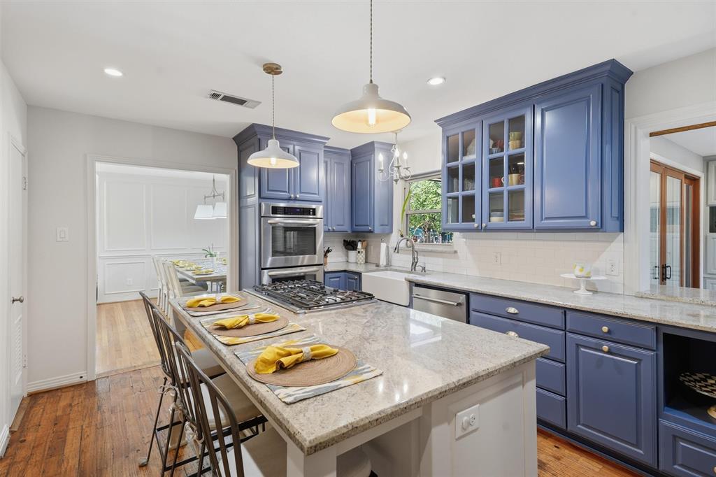 3712 Brighton Road Fort Worth, TX 76109 - Photo 5 of 33 Stylish chef kitchen featuring custom blue cabinetry and a center island with seating