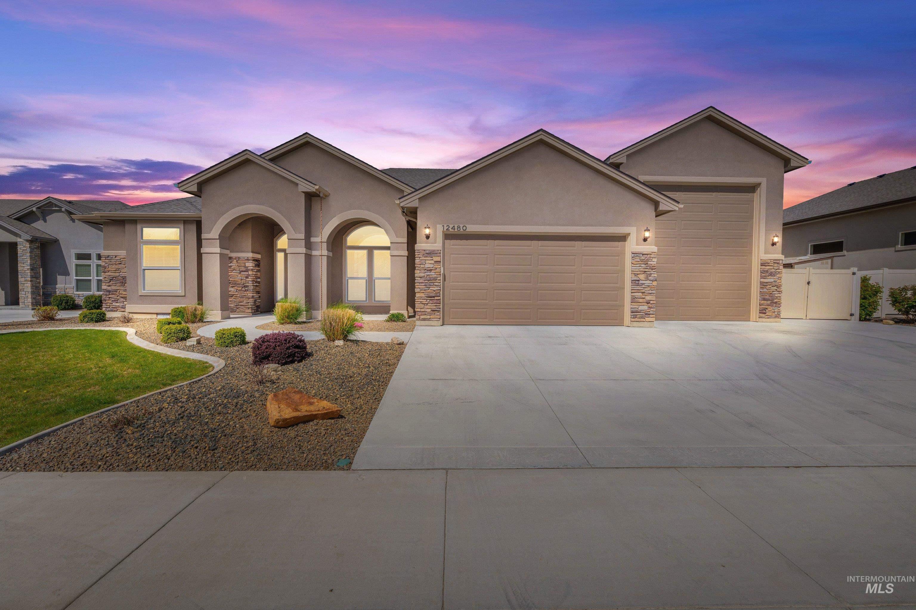 12480 West Superior Street Star, ID 83669 - Photo 1 of 1 Ranch-style house featuring an attached garage, stucco siding, driveway, stone siding, and a gate