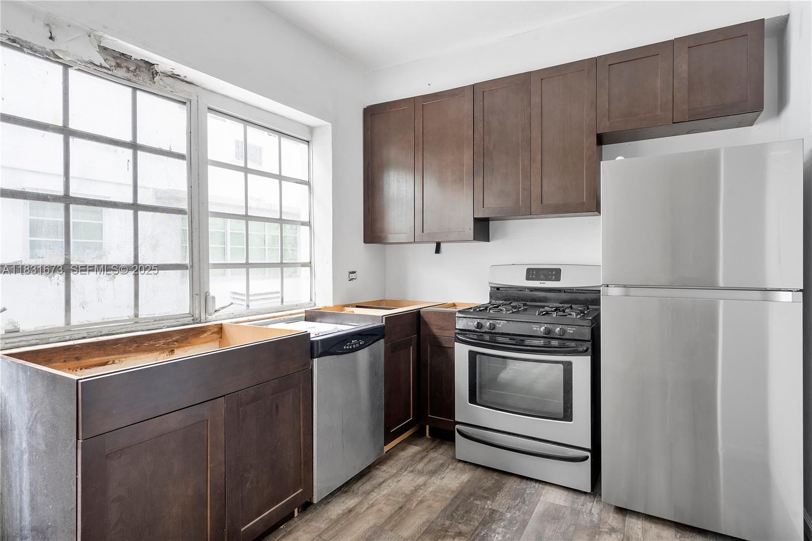 836 10th Street, Unit 6 Miami Beach, FL 33139 - Photo 5 of 12 a kitchen with stainless steel appliances granite countertop a stove a refrigerator and a sink
