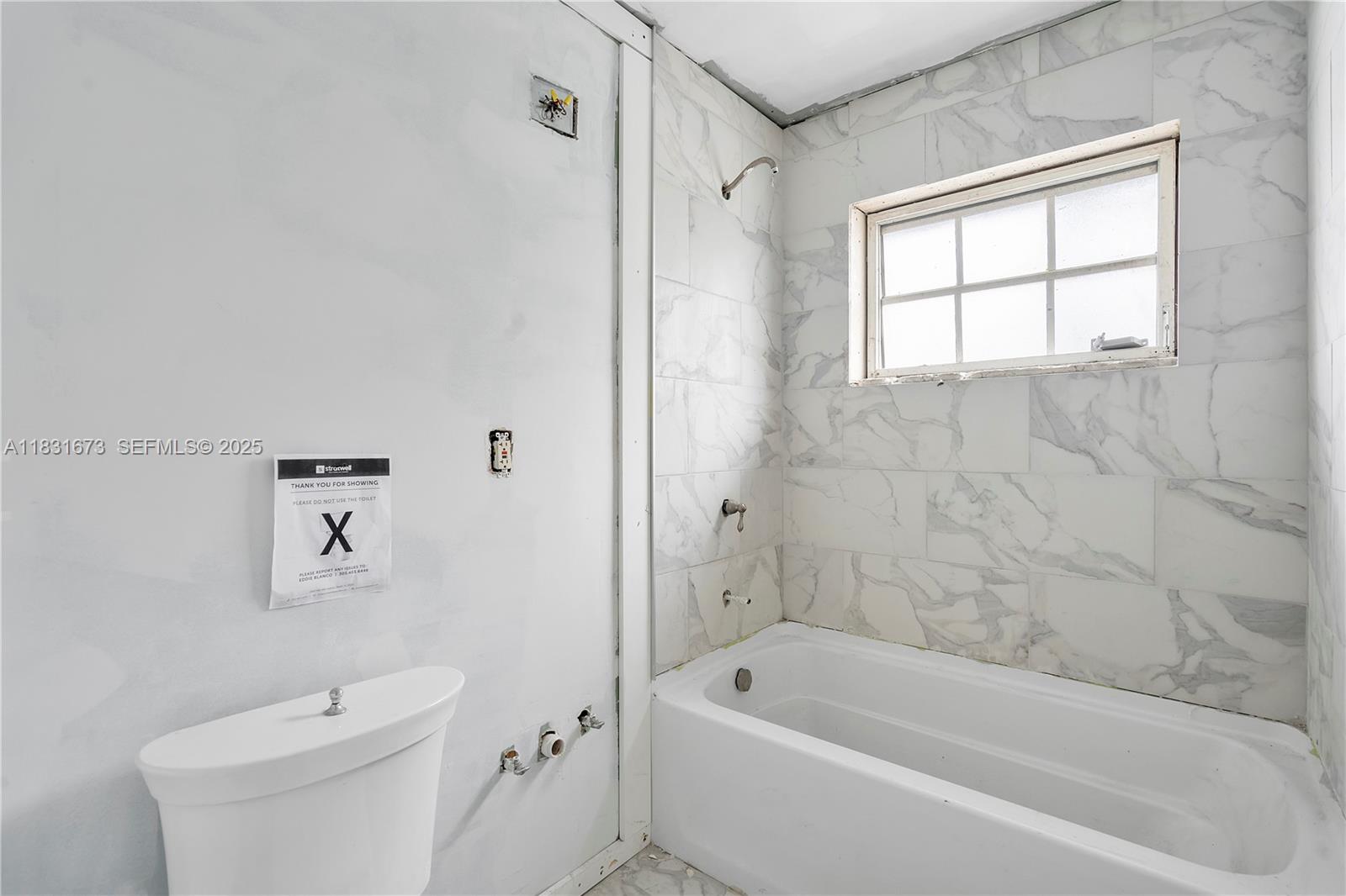 836 10th Street, Unit 6 Miami Beach, FL 33139 - Photo 10 of 12 a white bath tub sitting next to a white toilet and a shower