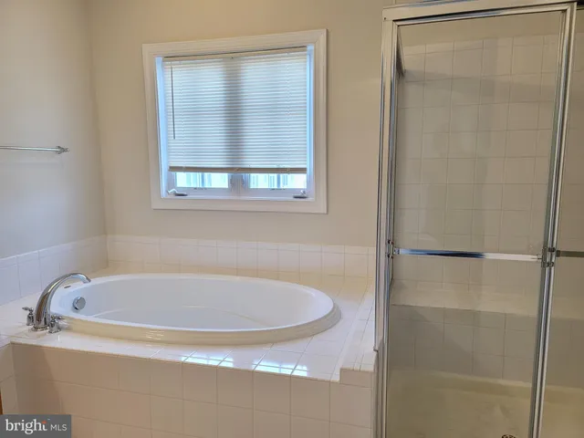 a white bath tub sitting next to a shower