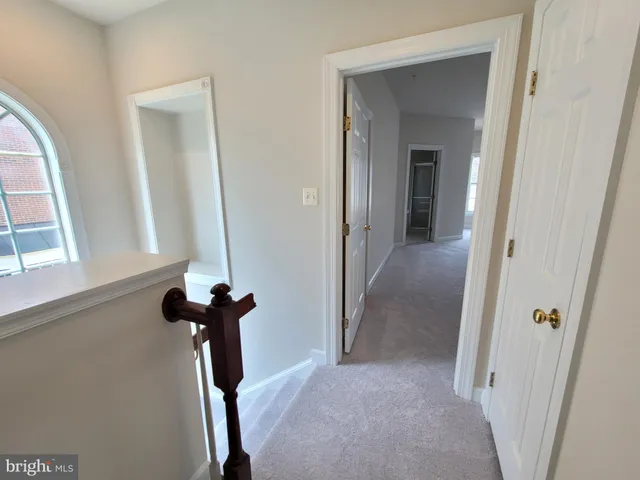 a view of staircase with railing and white walls