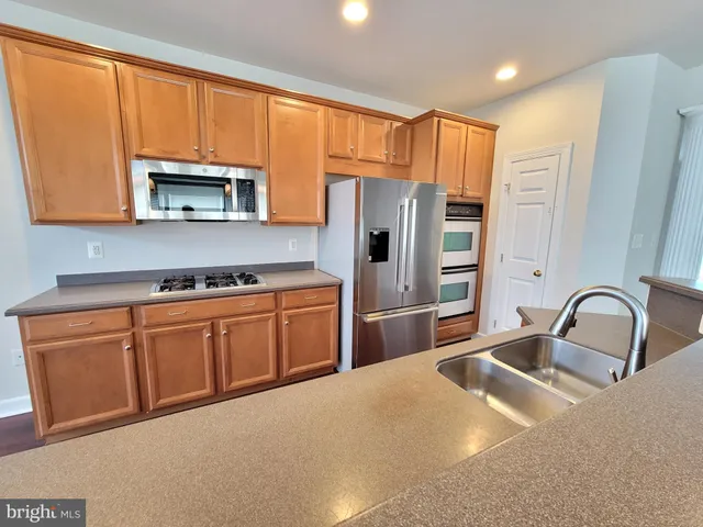 a kitchen with stainless steel appliances granite countertop a refrigerator sink and microwave
