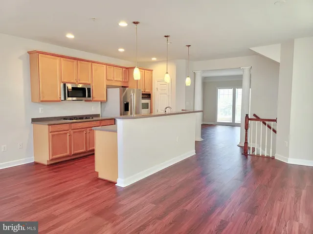 a large kitchen with cabinets and wooden floor