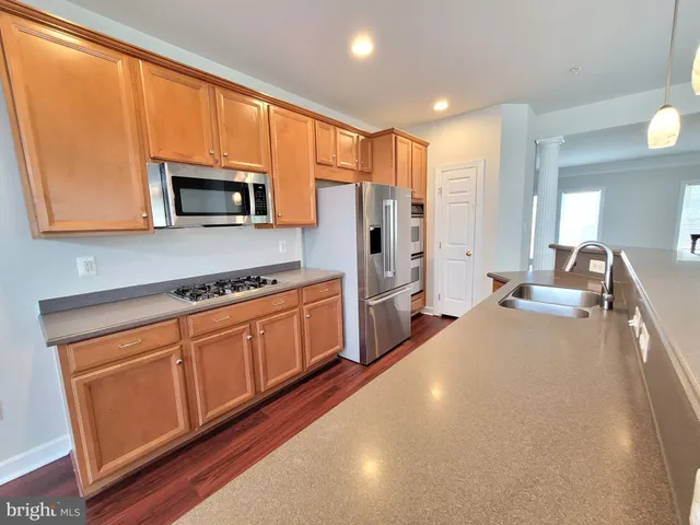 a kitchen with stainless steel appliances a stove microwave and sink