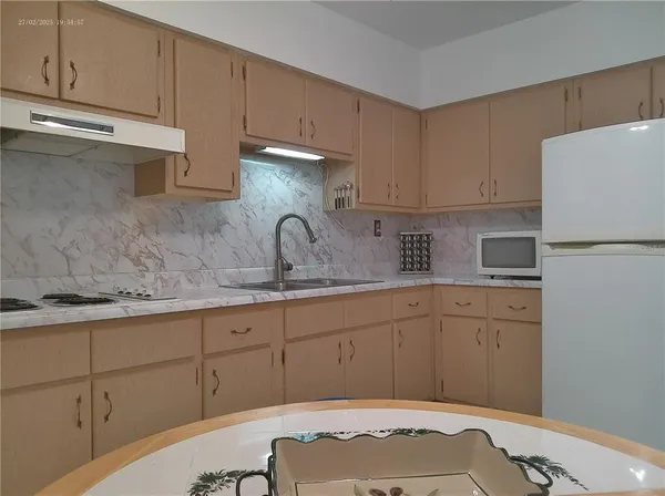 a kitchen with stainless steel appliances granite countertop a refrigerator sink and cabinets