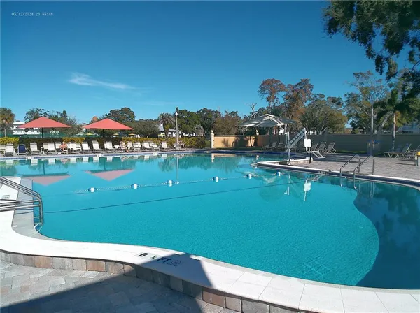 a room with lots of wooden furniture and swimming pool