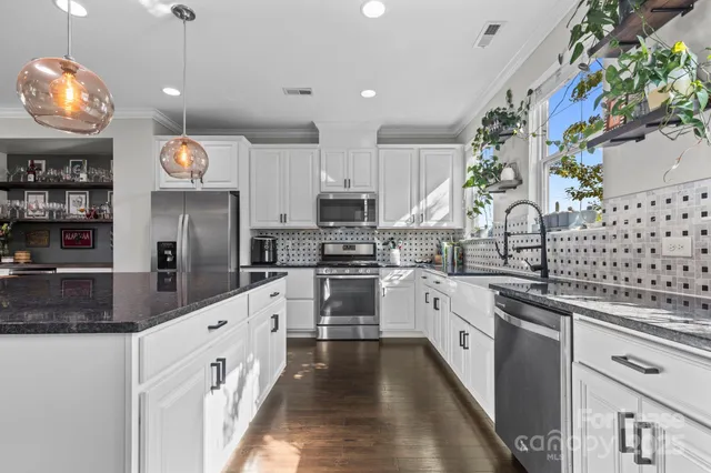 a kitchen with stainless steel appliances granite countertop a stove and cabinets