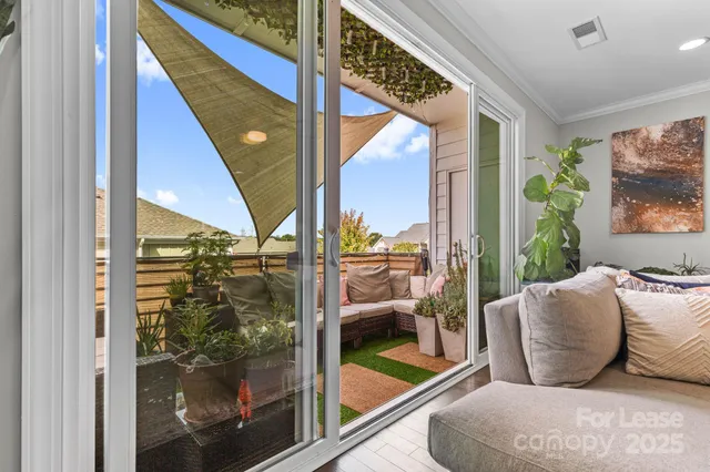 a living room with furniture and a floor to ceiling window