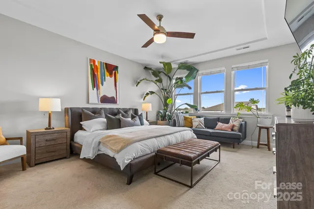 a bedroom with a bed a couch and a potted plant