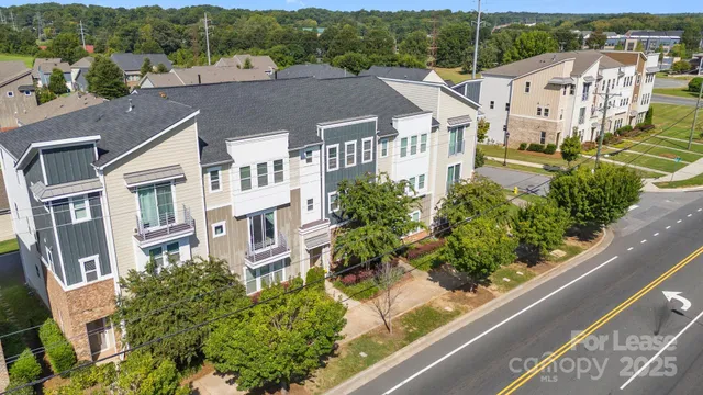 an aerial view of residential houses with outdoor space and trees