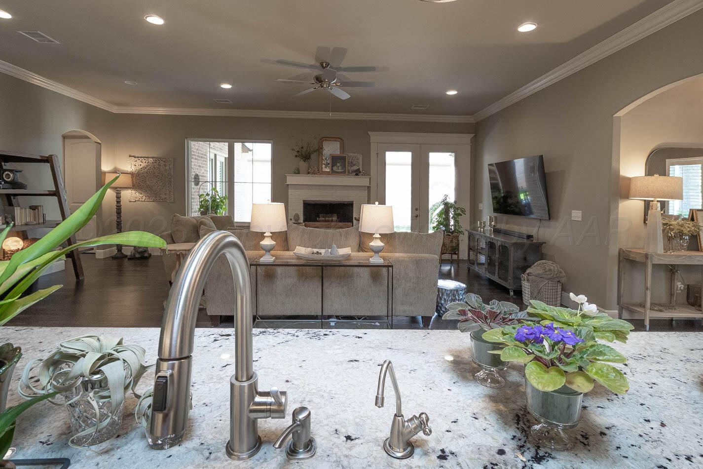 6809 Baccus Amarillo, TX 79124 - Photo 13 of 20 a living room with furniture a flat screen tv and a floor to ceiling window