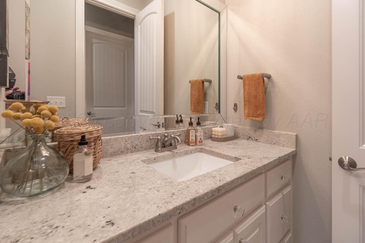 6809 Baccus Amarillo, TX 79124 - Photo 15 of 20 a bathroom with a granite countertop sink and a mirror