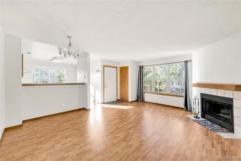 wooden floor fireplace and windows in an empty room