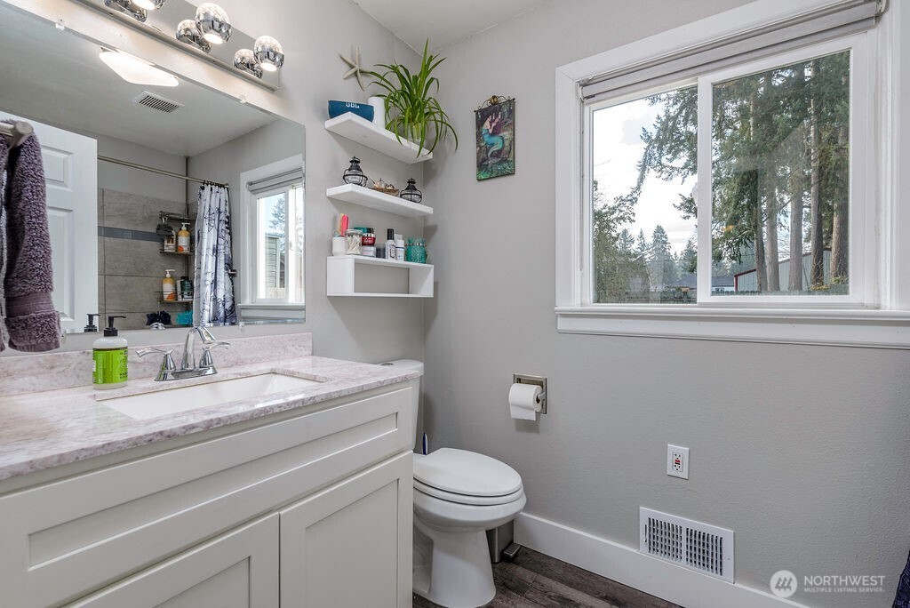 814 117th Street South Tacoma, WA 98444 - Photo 11 of 22 a bathroom with a granite countertop toilet sink and mirror