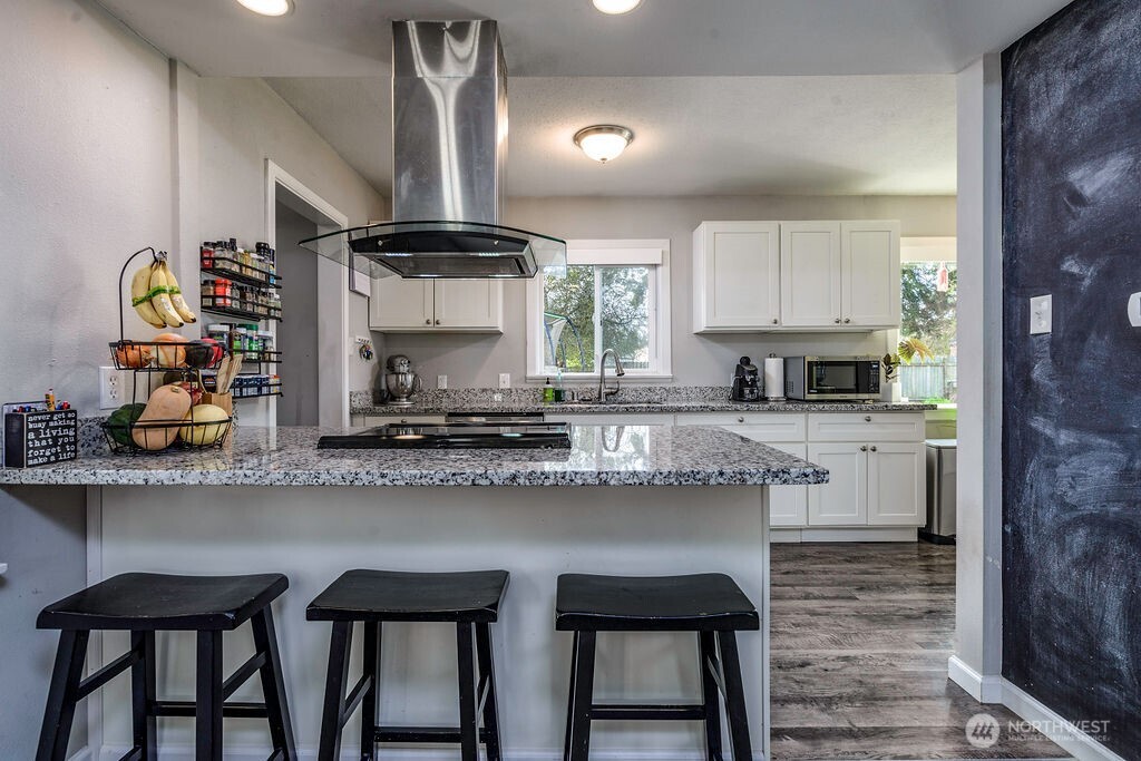 814 117th Street South Tacoma, WA 98444 - Photo 7 of 22 a kitchen with granite countertop a table chairs stove and cabinets