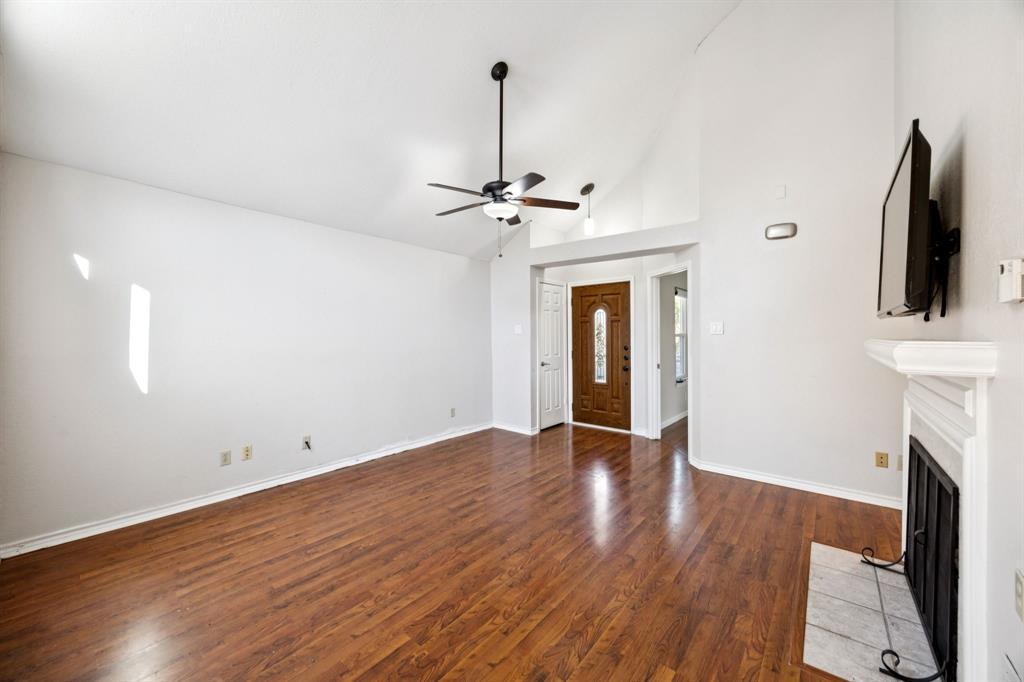 18111 Whispering Gables Lane Dallas, TX 75287 - Photo 3 of 15 wooden floor in an empty room with a fireplace