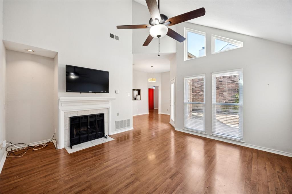 18111 Whispering Gables Lane Dallas, TX 75287 - Photo 4 of 15 a view of a livingroom with a fireplace a ceiling fan and wooden floor