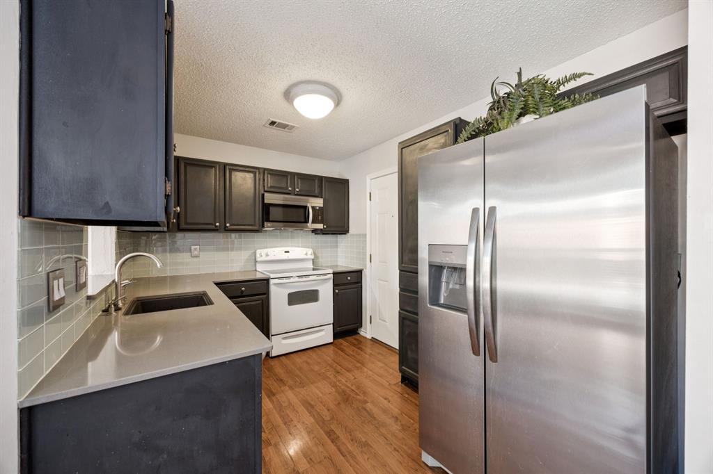18111 Whispering Gables Lane Dallas, TX 75287 - Photo 5 of 15 a kitchen with a refrigerator sink and microwave