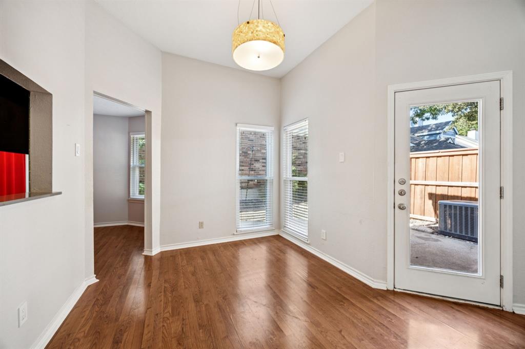 18111 Whispering Gables Lane Dallas, TX 75287 - Photo 7 of 15 an empty room with wooden floor cabinet and windows