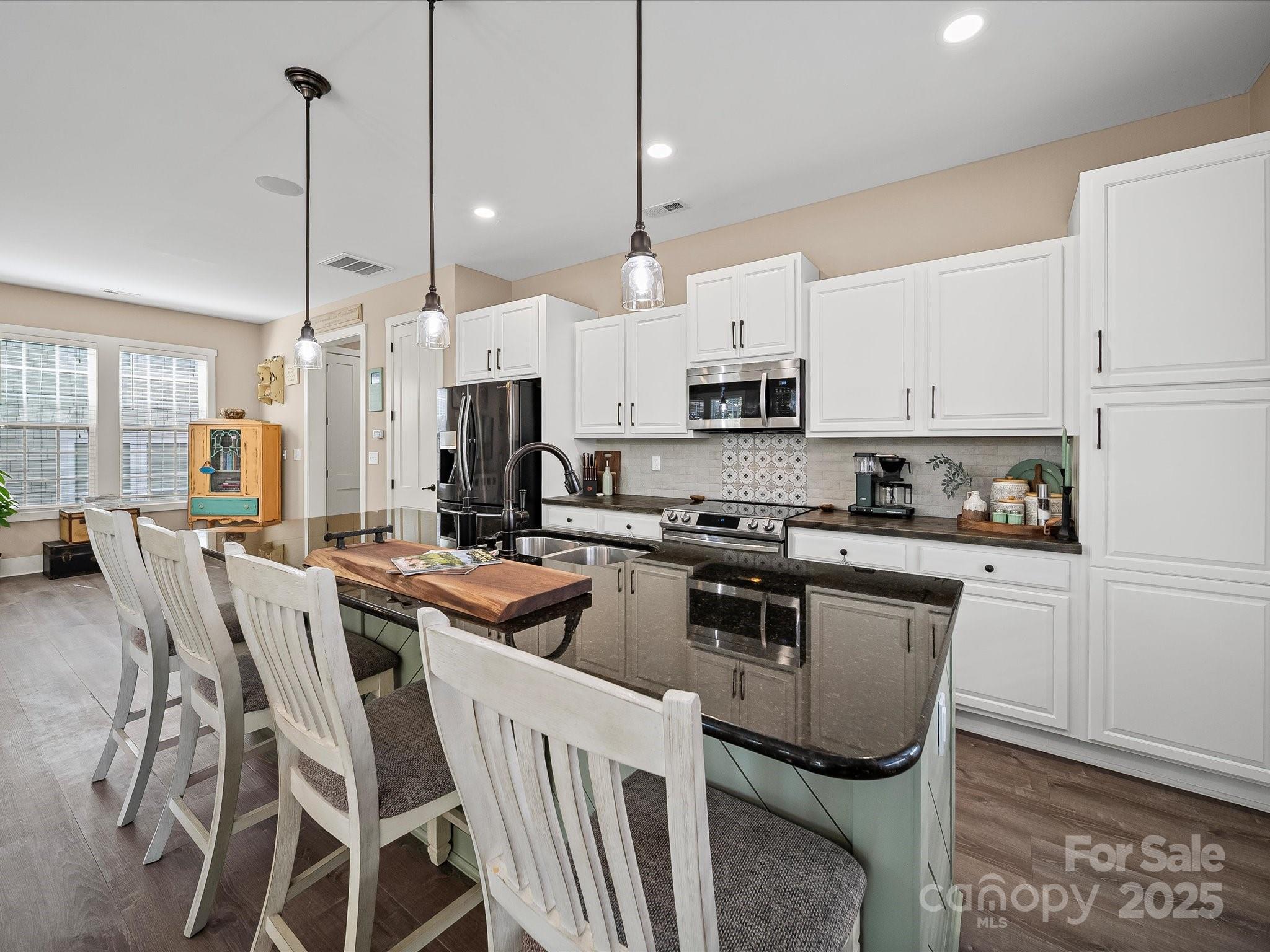 28117 Egrets Court Lancaster, SC 29720 - Photo 14 of 46 a kitchen with stainless steel appliances a stove a sink a refrigerator a center island a dining table and chairs