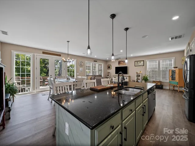 a kitchen with stainless steel appliances granite countertop a stove a sink and a white cabinets
