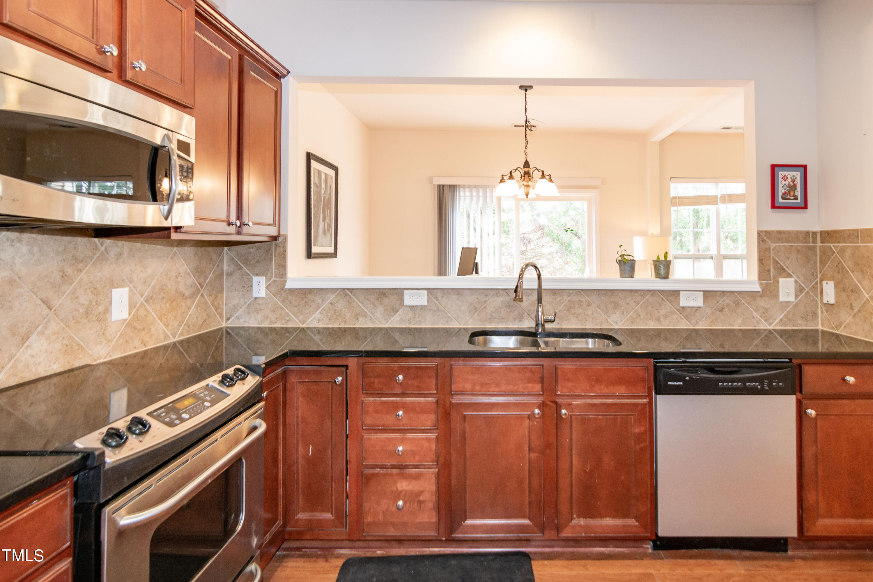 8621 Thunderwood Drive Raleigh, NC 27617 - Photo 12 of 35 a kitchen with stainless steel appliances granite countertop a sink and a stove