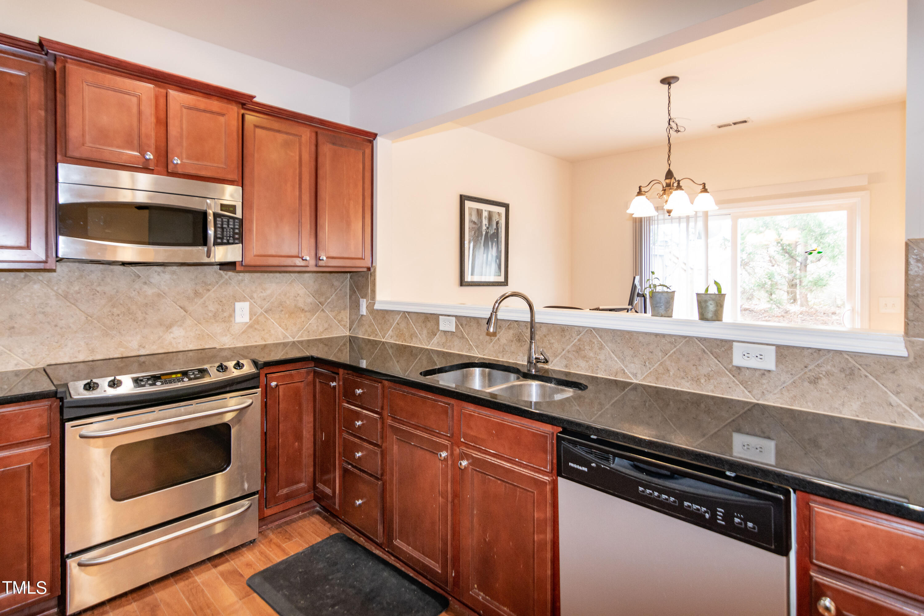 8621 Thunderwood Drive Raleigh, NC 27617 - Photo 13 of 35 a kitchen with stainless steel appliances granite countertop a sink stove and microwave