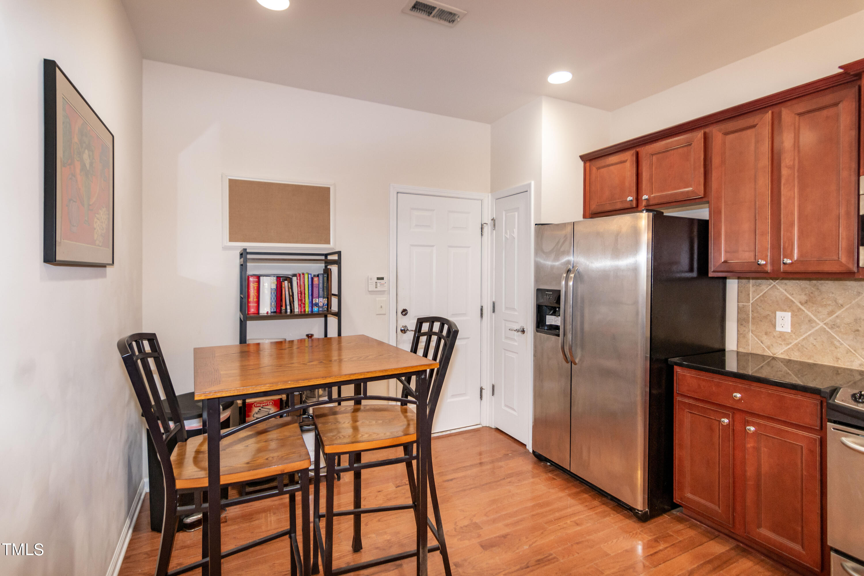 8621 Thunderwood Drive Raleigh, NC 27617 - Photo 15 of 35 a dining room with stainless steel appliances a refrigerator and wooden furniture