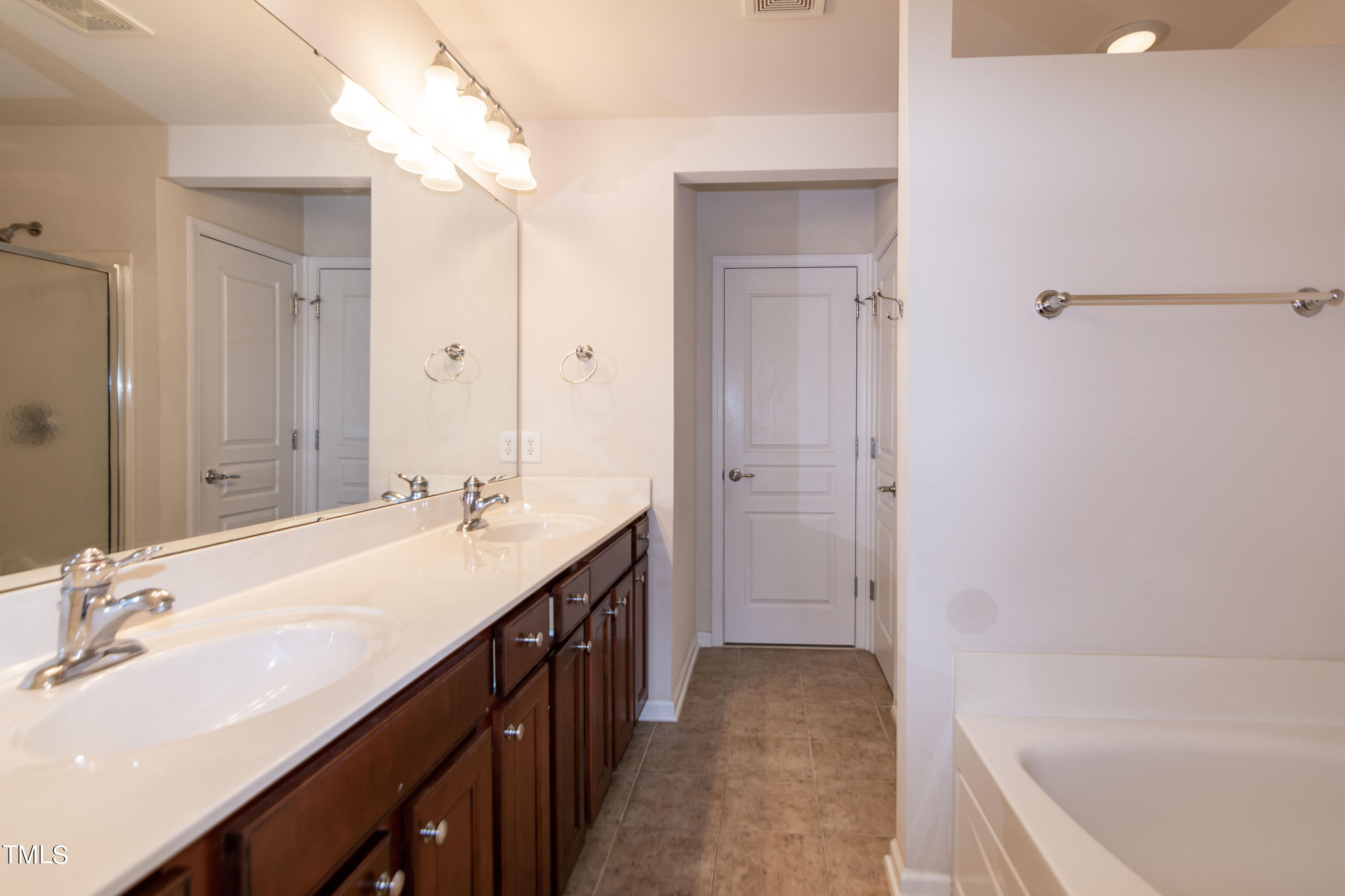 8621 Thunderwood Drive Raleigh, NC 27617 - Photo 20 of 35 a bathroom with a tub sink and mirror