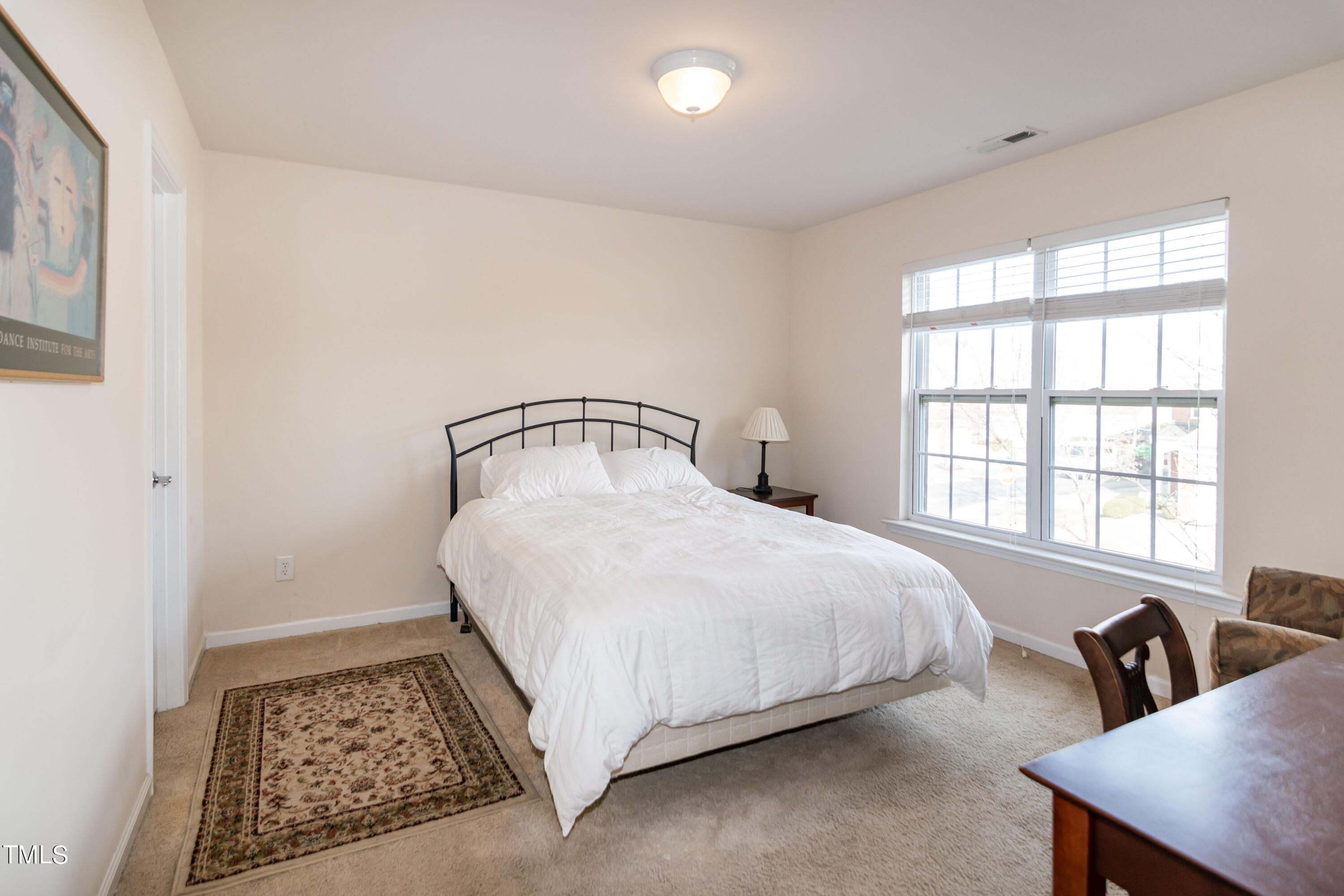 8621 Thunderwood Drive Raleigh, NC 27617 - Photo 24 of 35 a bedroom with a bed a table and chair