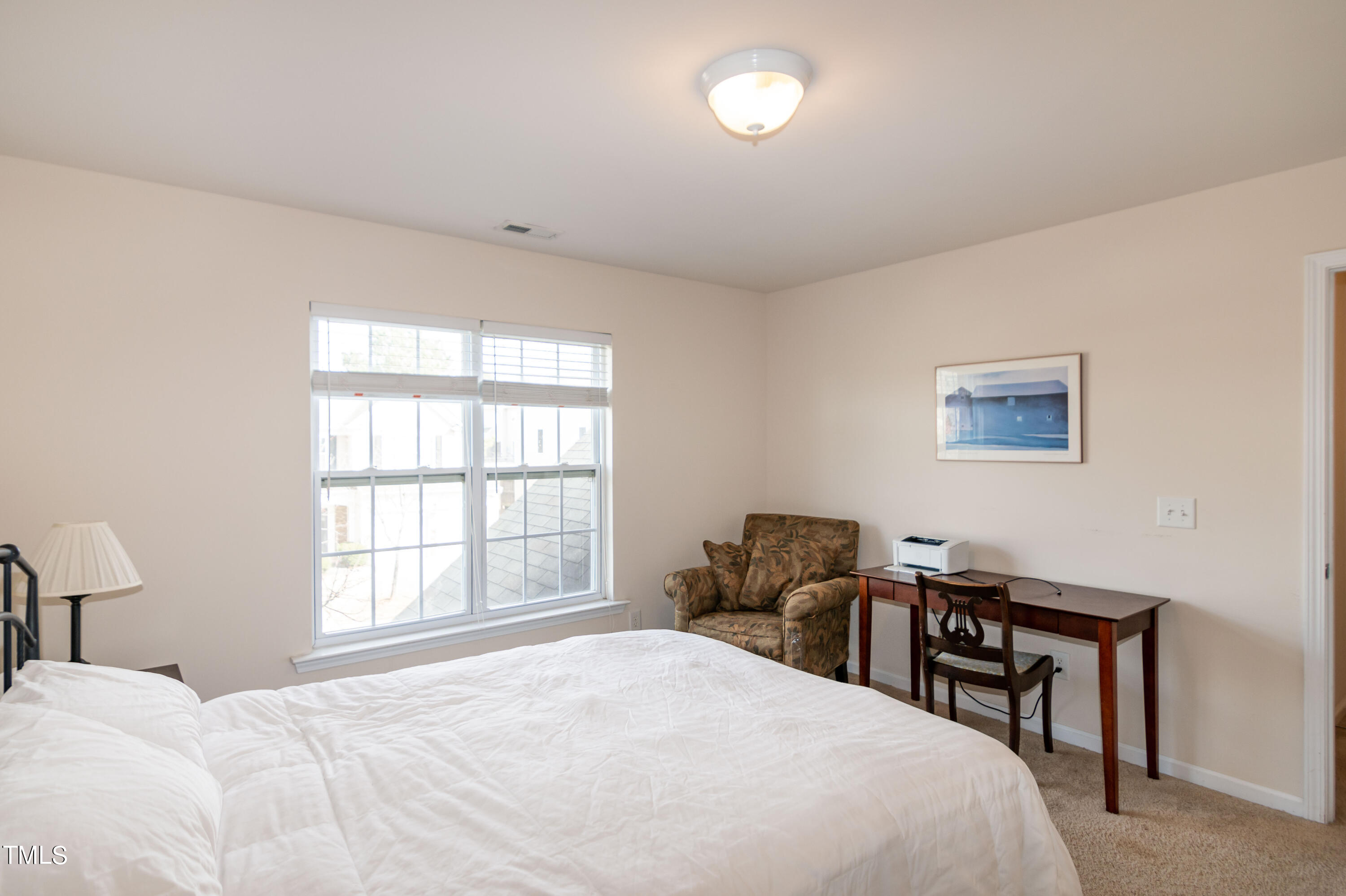 8621 Thunderwood Drive Raleigh, NC 27617 - Photo 25 of 35 a bedroom with a bed table chair and a window