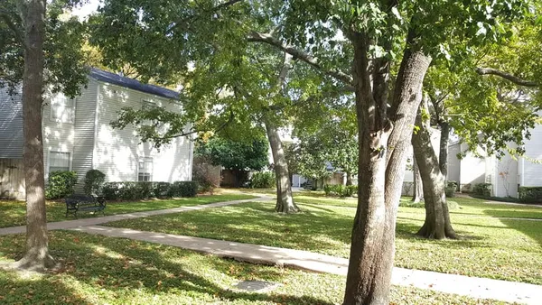 a backyard of a house with lots of green space and fountain