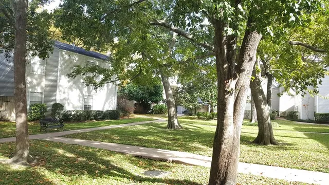 a backyard of a house with lots of green space and fountain