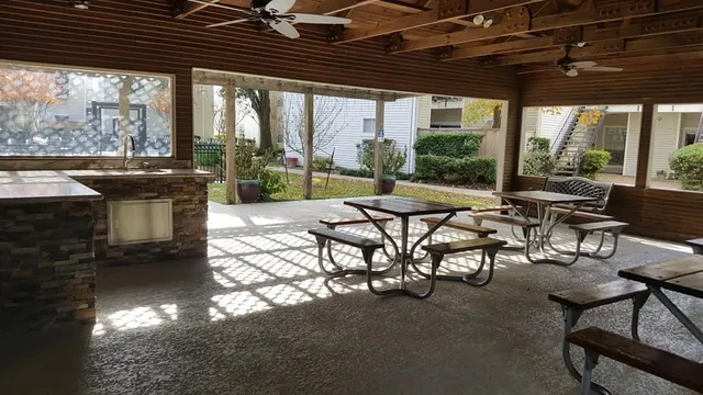 a view of a patio with table and chairs and couches with wooden floor and fence
