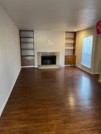 a view of an empty room with a fireplace and a window