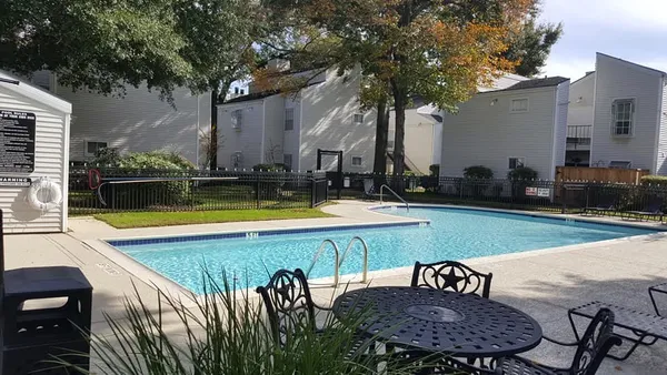 a view of a swimming pool with a lounge chair and a tree