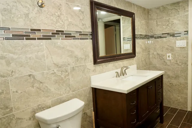 a bathroom with a sink a toilet and mirror