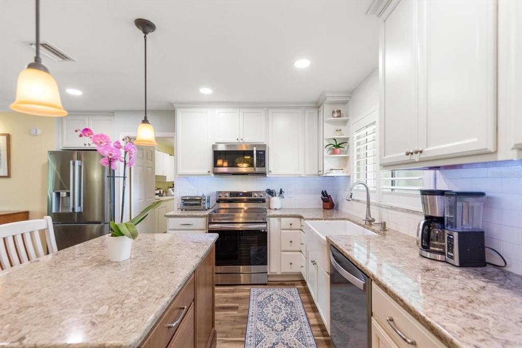 7133 Augusta Boulevard Seminole, FL 33777 - Photo 11 of 54 a kitchen with granite countertop a sink a counter top space appliances and cabinets