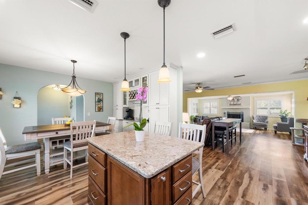 7133 Augusta Boulevard Seminole, FL 33777 - Photo 15 of 54 a room with stainless steel appliances kitchen island granite countertop a table chairs and a wooden floor