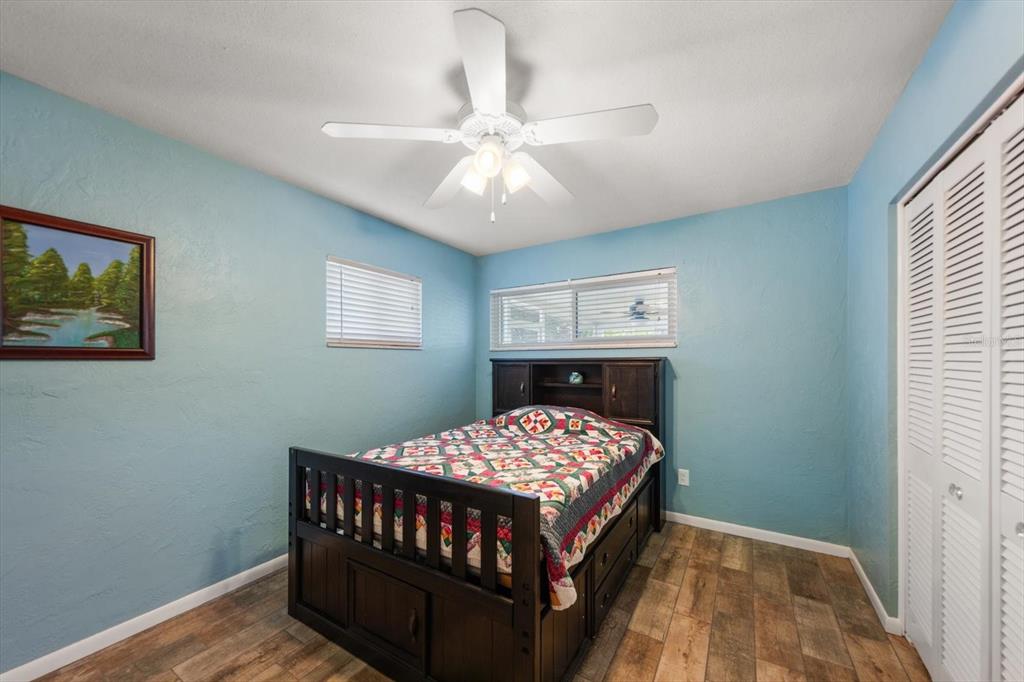 7133 Augusta Boulevard Seminole, FL 33777 - Photo 24 of 54 a bedroom with a bed and a chandelier