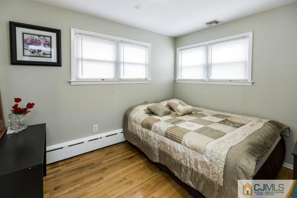106 Normandy Road Colonia, NJ 07067 - Photo 16 of 25 a bed sitting in a bedroom next to a window