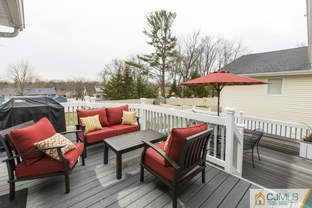 106 Normandy Road Colonia, NJ 07067 - Photo 24 of 25 a roof deck with a table and chairs under an umbrella with wooden floor