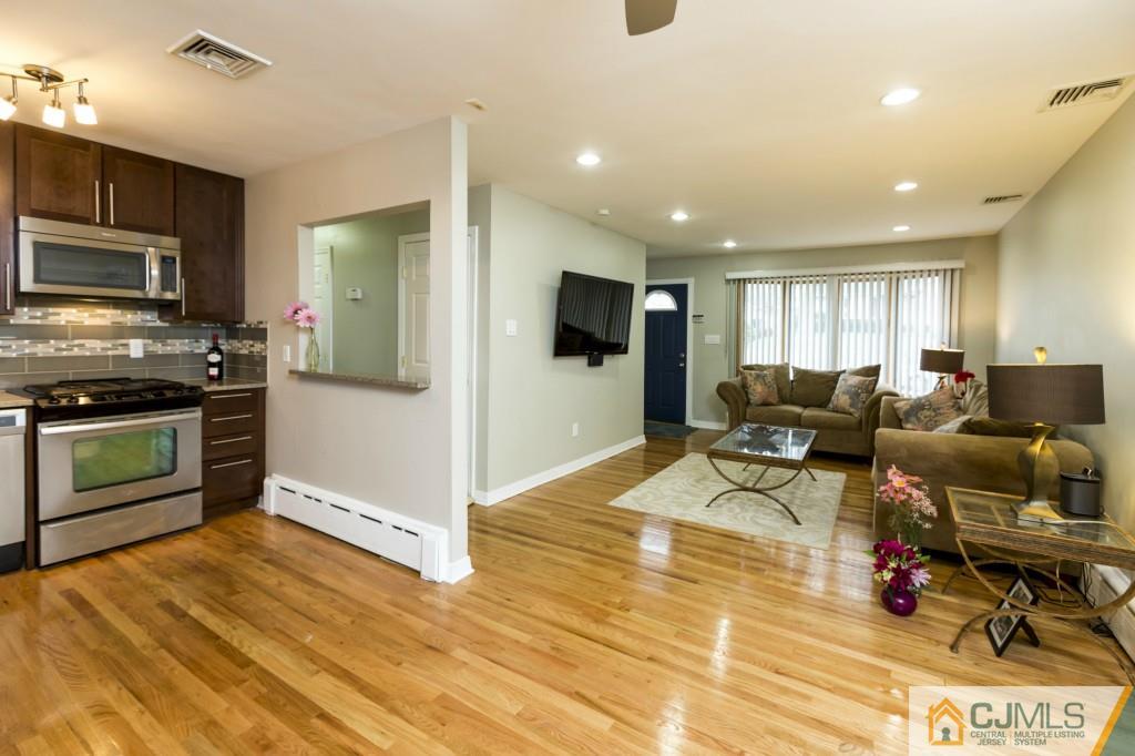 106 Normandy Road Colonia, NJ 07067 - Photo 9 of 25 a living room with stainless steel appliances furniture stove and kitchen view