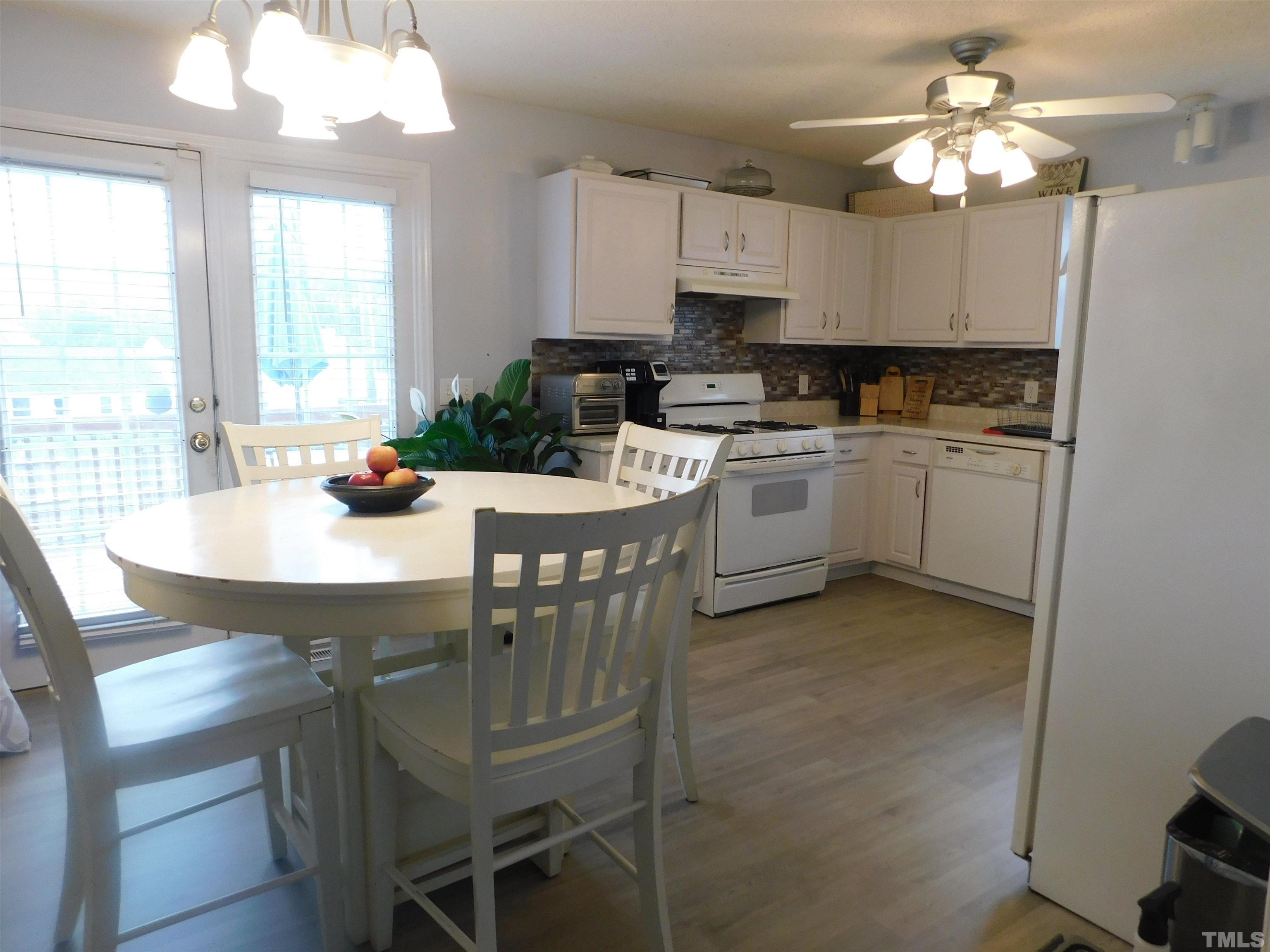 4017 Mardela Spring Drive Raleigh, NC 27616 - Photo 8 of 23 a kitchen with a dining table chairs stainless steel appliances and cabinets