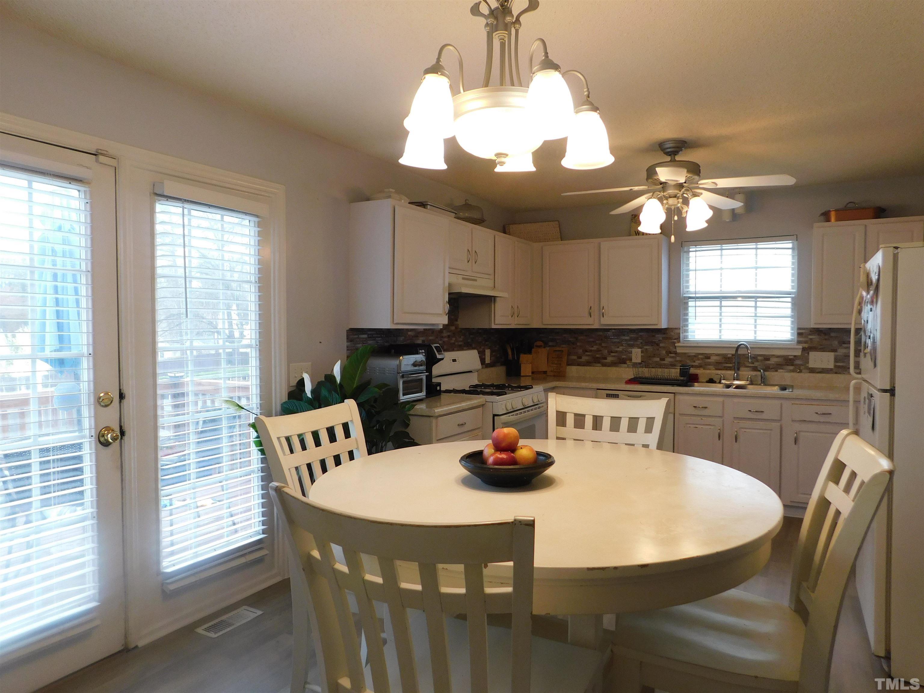 4017 Mardela Spring Drive Raleigh, NC 27616 - Photo 9 of 23 a kitchen with a table chairs and white cabinets