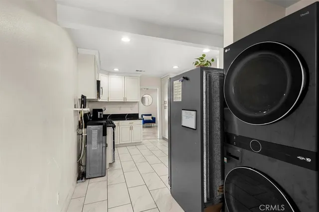 a kitchen with stainless steel appliances a sink a stove a washer and dryer